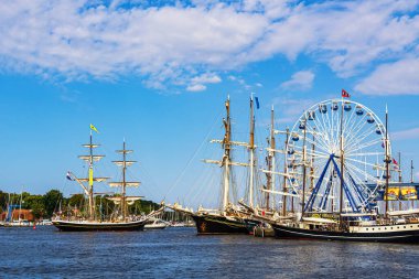 Almanya, Rostock 'taki Hanse Yelkenlisi sırasında Warnow nehrinde yelken açan gemiler..