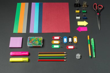 Canlı bir el işi malzemesi dizisi karanlık bir yüzeye yayılır. Renkli kağıtlar, makas, klipler ve kırtasiye malzemeleri sanatsal çabaları bekliyor, her ayrıntıda ilham ve yaratıcılığı davet ediyor..