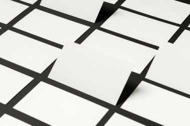 Boş kartların bir koleksiyonu karanlık bir yüzeyde ızgara deseninde düzenlenir. Her kart, yaratıcılığı ve fikirleri davet eden şaşırtıcı bir görsel efekt yaratarak hafifçe yükseltilmiş durumda..