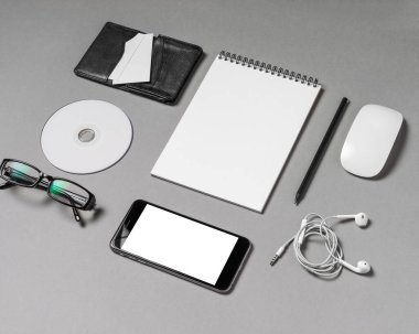 Akıllı telefon, defter, fare ve diğer nesnelerin şık bir şekilde küçük gri bir yüzeye yerleştirilmesi. Kurulum, beyin fırtınası oturumları için ideal bir üretkenlik ve yaratıcılık duygusunu davet ediyor..