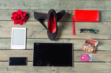 Modern temel eşyalardan oluşan bir koleksiyon ustalıkla kırsal ahşap bir masa üzerinde düzenlenmiştir..