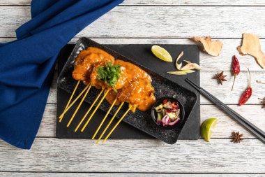 Üç şişe lezzetli ızgara et lezzetli bir sosla ıslanır ve ustalıkla koyu bir tabakta sergilenir. Yanında limon, taze otlar ve salata ile birlikte sedef gurme bir cazibe..