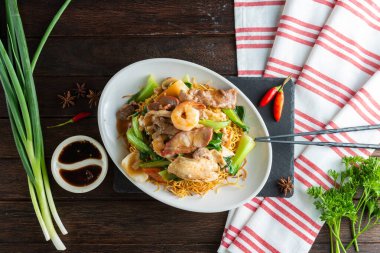 Canlı bir yemek, altın şehriye yatağında gevrek sebzelerle kızartılmış taze tavuk içerir. Taze bitkiler ve soslar renk ve tat katar. Lezzetli bir yemek için mükemmeldir..