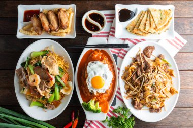 Canlı bir Asya mutfağı kırsal bir ahşap masada güzel bir şekilde düzenlenmiştir..