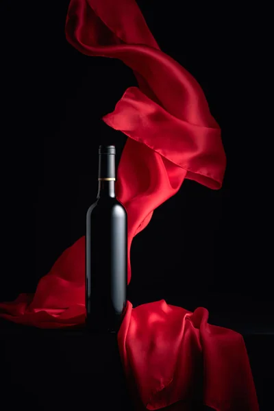 Flasche Rotwein Auf Schwarzem Hintergrund Mit Flatterndem Rotem Tuch — Stockfoto