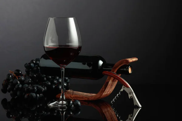Rode Wijn Kurkentrekker Blauwe Druiven Een Zwarte Reflecterende Achtergrond — Stockfoto