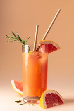 Summer cocktail with grapefruit, rosemary, and ice in a frozen glass.