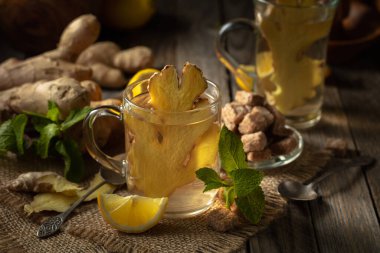 Limonlu zencefilli çay ve cam bardakta nane kırsal tarzda eski bir tahta..