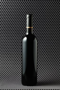 Gri bir arka planda bir şişe kırmızı şarap.. 