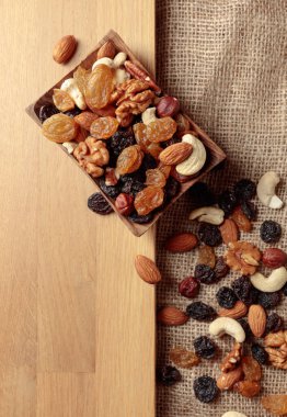 Kurutulmuş meyve ve fındık. Tahta bir masada fındık ve kuru üzüm karışımı. Kopyalama alanı olan üst görünüm.