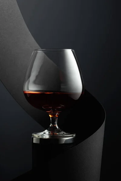 Snifter of brandy on a black background.