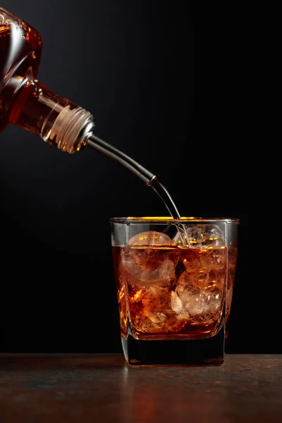 Whisky Viene Versato Una Bottiglia Bicchiere Con Ghiaccio — Foto Stock