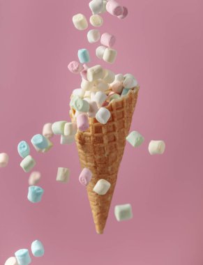 Küçük renkli şekerlemeler waffle külahına düşer..