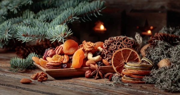 古い木製のテーブルの上に果物やナッツを乾燥させます 乾燥柑橘類 アプリコット レーズン 様々なナッツ シナモンスティック アニスとクリスマスの静物画 — ストック写真