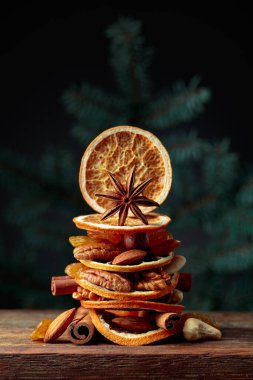 Eski ahşap bir masada kurumuş meyve ve fındık. Çam ağacından dalları olan bir Noel..