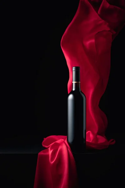 Μπουκάλι Κόκκινο Κρασί Μαύρο Φόντο Flutters Κόκκινο Πανί Αντιγραφή Χώρου — Φωτογραφία Αρχείου