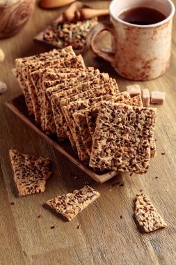 Tahta bir masada ayçekirdeği ve keten tohumlu çıtır krakerler..