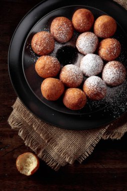 Balls of freshly baked homemade cottage cheese doughnuts sprinkled with sugar powder. Top view.