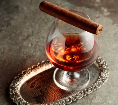 Gümüş tepside bir parça brendi ve puro. Boşluğu kopyala.