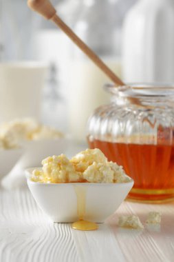 Taze ev yapımı süzme peynir ya da beyaz ahşap bir masada ballı ricotta..