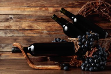 Red wine and blue grapes. Wine and grapes in a vintage setting on an old wooden table.