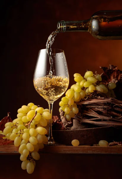 白ワインをグラスに注ぐ 白ワインとブドウの束ヴィンテージ木製テーブル — ストック写真