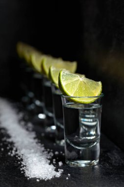Siyah bir arkaplanda limonlu ve deniz tuzlu tekila..