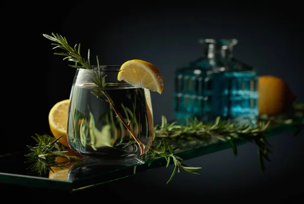 レモンとローズマリーと冷たいさわやかな飲み物 ガラスのテーブルの上の銀強壮カクテル — ストック写真