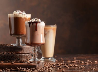 Kahverengi arka planda kremalı kahve ve çikolata içecekler. Cpoy alanı.