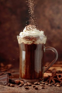 Çikolata kırıntıları serpiştirilmiş kremalı kahve. Malzemeli sıcak bayram içeceği..