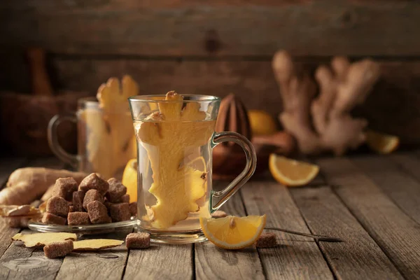Ginger tea with ingredients. Ginger, lemon, and brown sugar on an old wooden table.