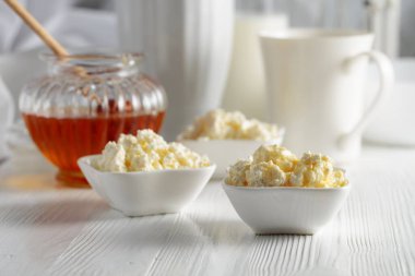 Taze ev yapımı süzme peynir ya da beyaz ahşap bir masada ballı ricotta..