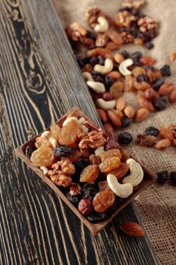 Kurutulmuş meyve ve fındık. Tahta bir masada fındık ve kuru üzüm karışımı..