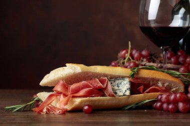 Jambon, mavi peynir ve karanlık bir arka plan üzerinde biberiye ile sandviç. Metniniz için kopya alanı.