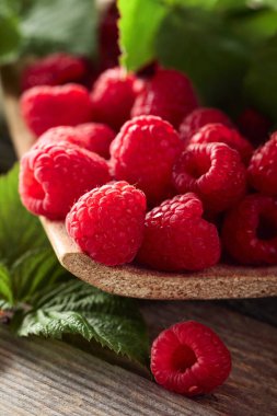 Eski ahşap arka planda yaprakları olan taze ahududular..