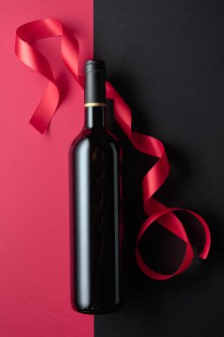 Bottle of red wine with satin ribbons. Top view. Copy space.