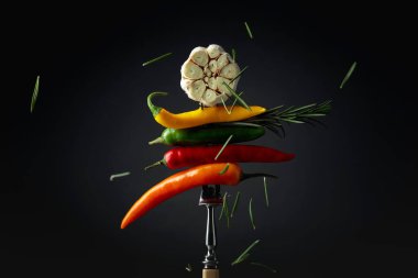 Red hot chili peppers with garlic and rosemary on a fork. Concept of spicy food.