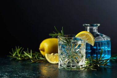 Kristal bardakta limon ve biberiyeli kokteyl cin toniği. Boşluğu kopyala.