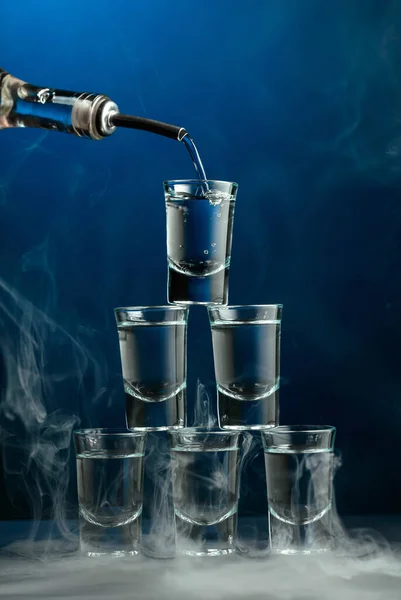 Vodka Wordt Uit Een Fles Gegoten Een Glas Rook Donkerblauwe — Stockfoto