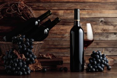 Red wine and blue grapes. Wine and grapes in a vintage setting on an old wooden table.