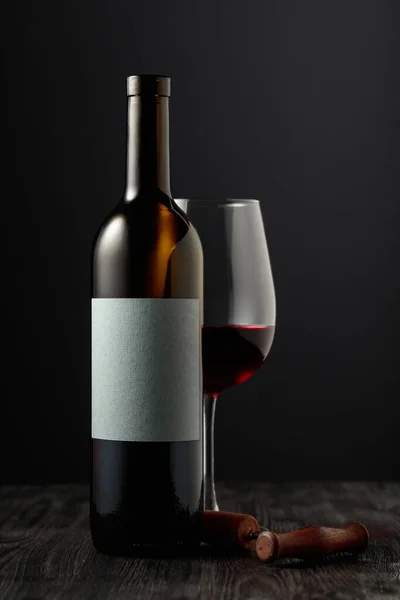 黒を基調とした赤ワインとコルク栓抜き あなたのテキストのためのボトルの空のラベルで — ストック写真