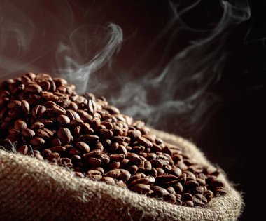 Orta pişmiş kahve çekirdekleri çuval içinde dumanlıdır..