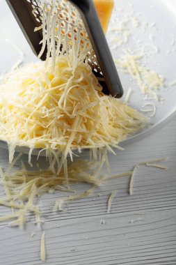 Rendelenmiş peynir ve rende. Konsept: İtalyan mutfağı, peynir, restoran ve yemek. Seçici odak.