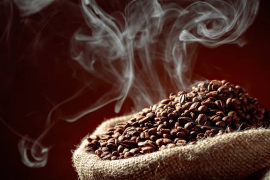 Orta pişmiş kahve çekirdekleri çuval içinde dumanlıdır..