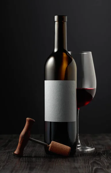 红葡萄酒和瓶塞螺丝黑色背景 在一个空标签上写上你的文字 — 图库照片