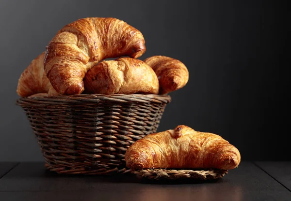 Fresh croissants on a black ceramic table. Traditional French kitchen.