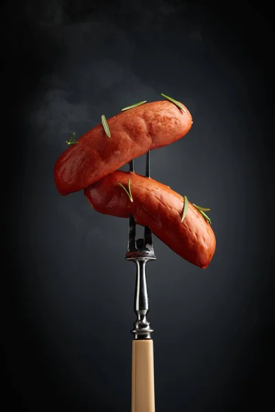 Boiled Sausages Rosemary Fork Hot Sausages Smoke Black Background — Stockfoto