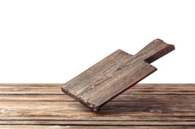 Cutting board falling on an old wooden table. Food preparation. Culinary background. Empty wooden cutting board, product display space.