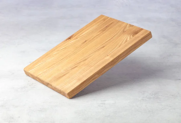 灰色の石のテーブルの上に落ちるまな板 料理の背景 空の木製のまな板 製品表示スペース — ストック写真