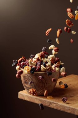Uçan kurutulmuş meyve ve fındık. Fındık ve kuru böğürtlen karışımı ahşap bir kasede.. 